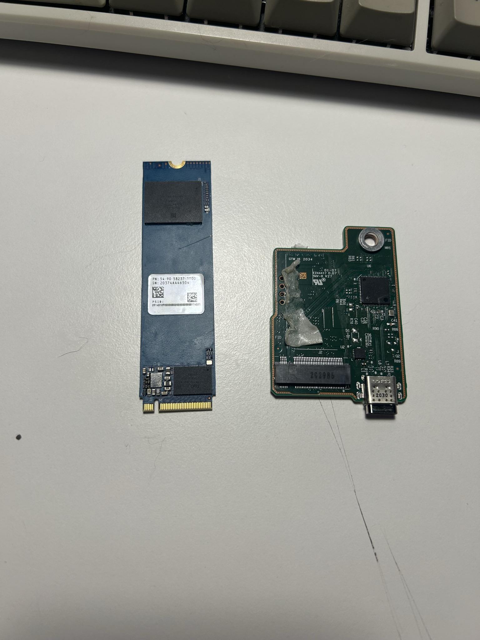 M.2 finally separated from the bridge board. That glue residue on the controller side is where SanDisk decided adhesive was the fix.